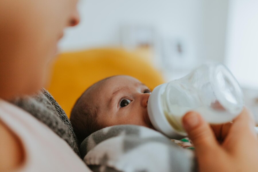 Mamá dándole fórmula a su bebé con agua purificada.