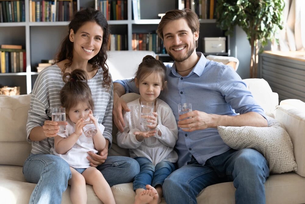 familia sonriendo tomando un vaso de agua